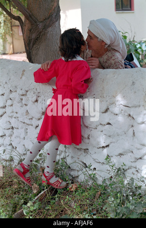 Giovani turche School girl saluto Sua nonna nel piccolo villaggio nel sud della Turchia occidentale. Foto Stock