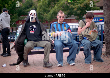 Tre giovani uomini seduti su una panchina durante una marcia di protesta nella zona est di Londra. Foto Stock