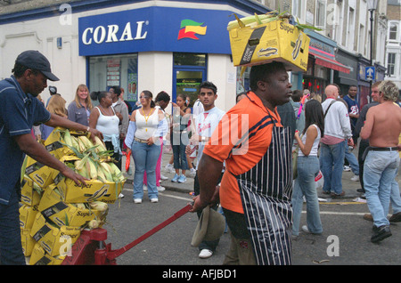 Portando il mais per la fornitura di un alimento in stallo al carnevale di Notting Hill a ovest di Londra. Foto Stock