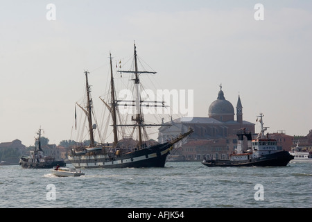 Ocean andando rimorchiatori tirare tre masted goletta a vela nel Canale della Giudecca passato San Giorgio Maggiore a Venezia Italia Foto Stock