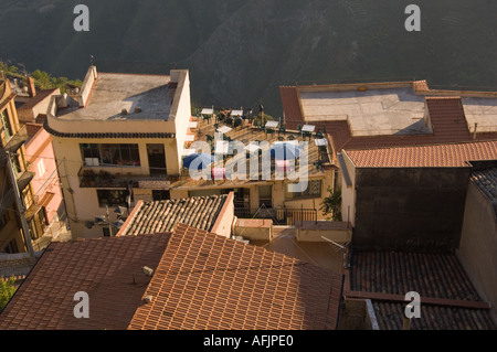 Vista sulla terra cotta sui tetti e patio sul tetto della cittadina collinare di Castelmola nella parte anteriore della base del Monte Etna Foto Stock