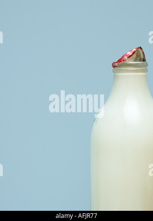 Bottiglia di latte su fondo azzurro Foto Stock