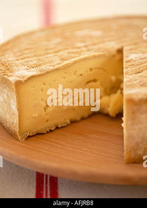 Formaggio francese con cuneo asportato su tavola di legno e tela di lino Foto Stock