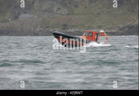 Orange costola rigida mondati barca gonfiabile RHIB su prove in mare a velocità in grigio il mare e il cielo off Ballycastle Irlanda del Nord Foto Stock