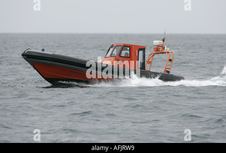 Orange costola rigida mondati barca gonfiabile RHIB su prove in mare a velocità in grigio il mare e il cielo off Ballycastle Irlanda del Nord Foto Stock