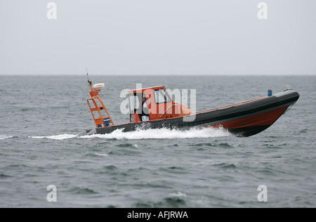 Orange costola rigida mondati barca gonfiabile RHIB su prove in mare a velocità in grigio il mare e il cielo off Ballycastle Irlanda del Nord Foto Stock