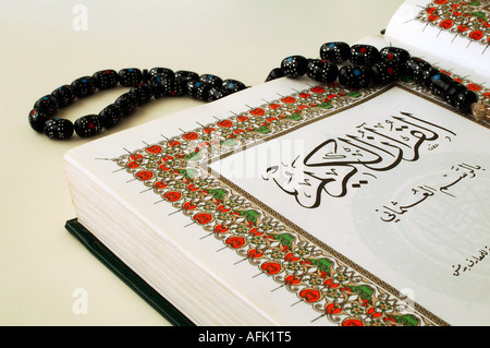 Una copia del testo sacro dell'Islam Corano aperto per la lettura con grani di preghiera chiamato Tasbeeh Foto Stock