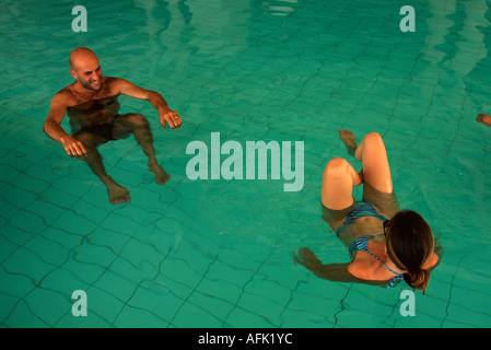 Vacanzieri galleggianti in piscina di acqua salata in una spa resort a Ein Bokek resort district riva del Mar Morto Israele Foto Stock