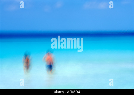 Moto sfocata immagine del giovane camminando nell'oceano in Cancun Messico Modello rilasciato Image Foto Stock