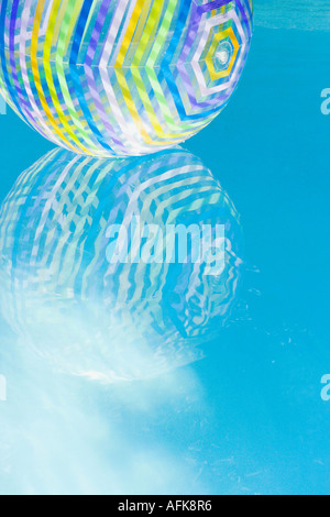 Palla spiaggia riflessa nella piscina con acqua Foto Stock