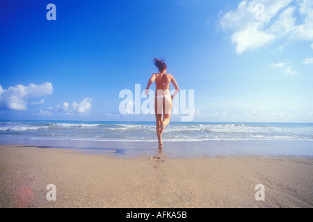 La donna in esecuzione sulla spiaggia verso il mare in Puerto Rico Caraibi Modello rilasciato foto Foto Stock
