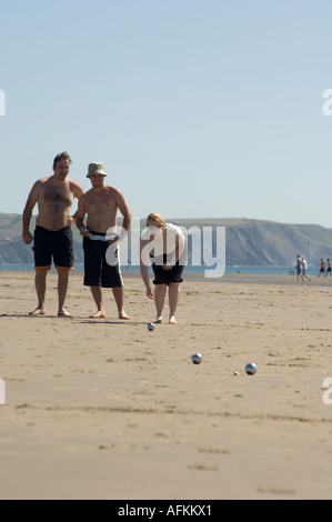 Pomeriggio estivo in Galles: tre giovani giocando a bocce sulla spiaggia Ynyslas e sabbie, Borth Ceredigion REGNO UNITO Foto Stock