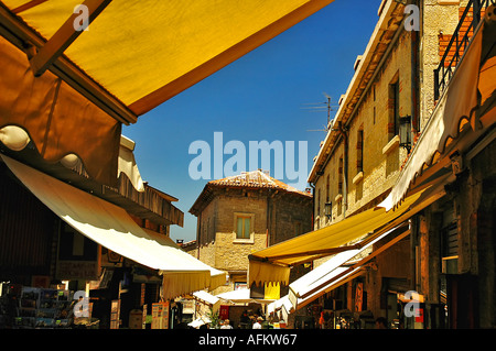 Le strette strade ricche di negozi in San Marino Tarps overhead per dare ombra. Foto Stock