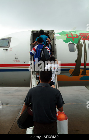 I passeggeri di salire a bordo di un aereo in Kunming legato per Mandalay. Foto Stock