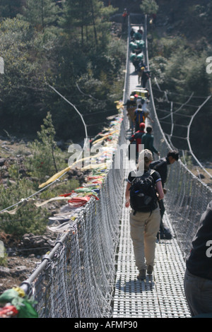 Bandiere di preghiera su un cavo di acciaio sospensione ponte sopra il latte Dood fiume sul modo di Namche Bazaar del Khumbu Nepal Foto Stock