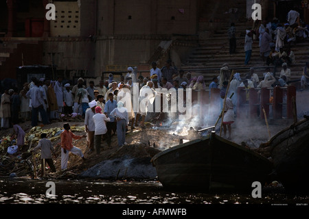 Versando sacro Gange acqua sulle ceneri presso il sito di cremazione sulle rive del Gange Varanasi India Foto Stock