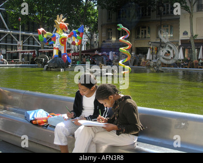 Due ragazze della scuola di disegno colorato presso la fontana di Tinguely a Place Igor Stravinsky Parigi Francia Foto Stock
