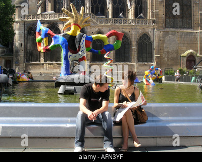 Coppia in cerca sulla mappa di Parigi a colorato la fontana di Tinguely a Place Igor Stravinsky Parigi Francia Foto Stock