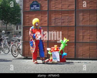 Clown solitaria la preparazione per il suo atto di palloncino in Rue St Merri 4° arr. Parigi Francia Foto Stock