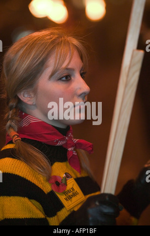 Una giovane donna maresciallo torcia attende a mano torce freschi, Lewes falò celebrazioni, East Sussex, Regno Unito Foto Stock