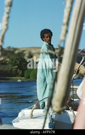 Vela in feluca sul fiume Nilo in Egitto un marinaio africano manzi e i rivestimenti la vela Foto Stock