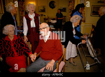 Casa di cura i residenti anziani del Regno Unito chiacchierano tra loro dopo il tè pomeridiano nella sala comune. Cirencester Gloucestershire 1990s UK Foto Stock