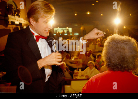 L'ipnotista Martin S Taylor esegue il suo spettacolo teatrale con un membro del pubblico seduto su una sedia. Bingo Hall North London UK 1980s 1985 HOMER SYKES Foto Stock