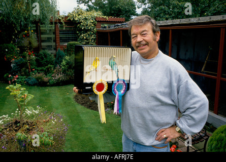 Barry Cross, proprietario dell'hotel Budgie, nel suo giardino. Gabbia per allevatori e hobbisti del suo vincitore Budgerigar Scunthorpe, Lincolnshire Inghilterra 1990s 1994 UK Foto Stock