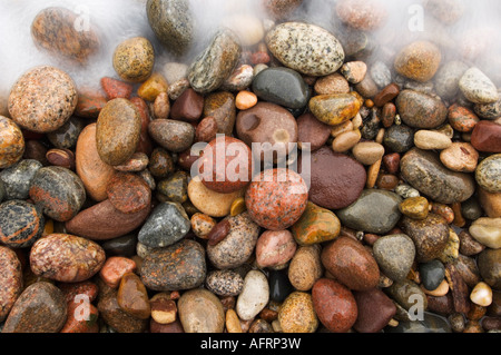 A schiantarsi onda si sposta oltre il coloratissimo Grandi Laghi spiaggia spiaggia di roccia sul lago Superiore, Michigan Foto Stock