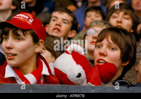 Anfield Liverpool tifosi di calcio 1980s in piedi nel Kop due giovani donne che hanno una mascotte rossa e bianca orso Teddy UK 1983 HOMER SYKES Foto Stock