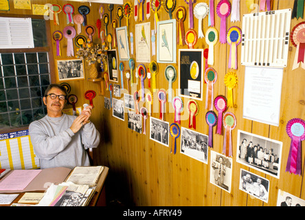 Barry Cross, proprietario dell'hotel Budgie, nel suo ufficio, è un allevatore e mostra i suoi uccelli. Rosette sul muro. Scunthorpe, Lincolnshire. Anni '1994 1990 Regno Unito Foto Stock