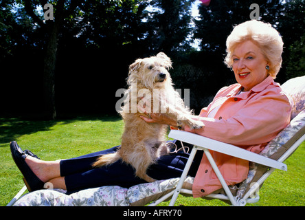 June Whitfield, ritratto, attrice televisiva attore. Nel giardino della sua casa di Wimbledon a Londra con un cane da compagnia. 1990 1990 UK HOMER SYKES Foto Stock