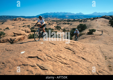 Gli amanti della mountain bike sul sentiero Slickrock vicino a Moab nello Utah Stati Uniti d'America Foto Stock