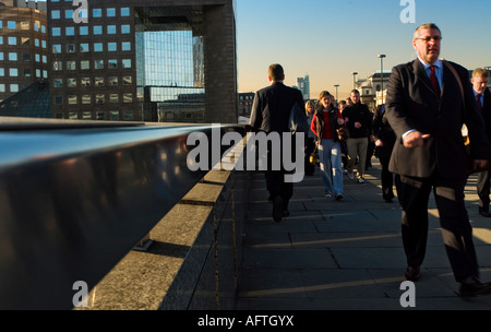 Andare al lavoro la mattina presto a chi lavora in ufficio camminando sul Ponte di Londra Foto Stock