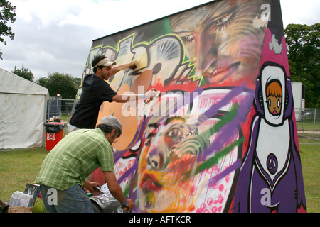 Due uomini di verniciatura a spruzzo mobile sul muro di graffiti presso il festival di musica, "Big Chill' 2007 Foto Stock