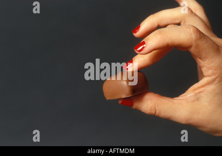 Mano che tiene il cioccolato, close up Foto Stock