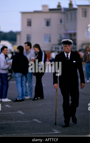 Cowes Week 1980s Regno Unito. Un vecchio marinaio anziano che usa bastone da passeggio nella sua uniforme navale. Cowes Regatta, Isola di Wight, Hampshire Regno Unito 1985 HOMER SYKES Foto Stock