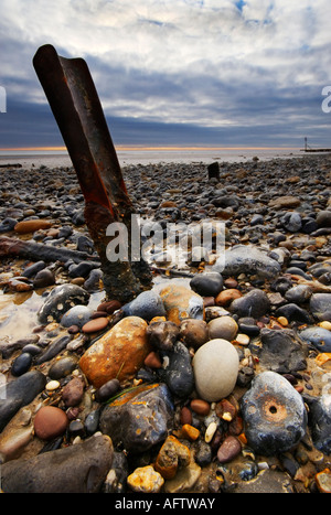 Un pezzo di ferro sporgente della sabbia sulla spiaggia a Mundesley Foto Stock