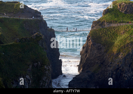 I turisti attraversano il carrick a rede ponte di corde sulla costa causeway famosa attrazione turistica Foto Stock