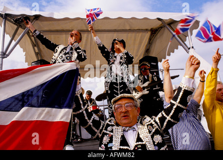 I Pearly Kings e i Queens cantano intorno alla band alla fine dei giorni corse Derby Horse race Epsom Downs Surrey UK. 1990S UK HOMER SYKES Foto Stock