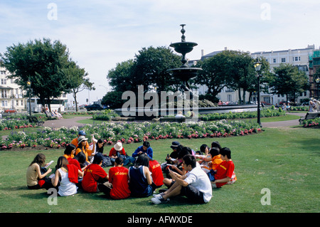 Studenti stranieri all'estero seduti sul prato Pavilion Gardens. Disteso sull'erba durante il sole estivo. Brighton East Sussex Inghilterra anni '2001 2000 Regno Unito Foto Stock