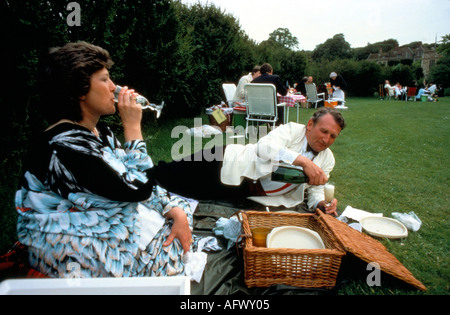 Picnic all'aperto degli anni '1980 nei giardini, giardini dell'Opera House durante il lungo intervallo, versando champagne Lewes Sussex 1984 UK HOMER SYKES Foto Stock