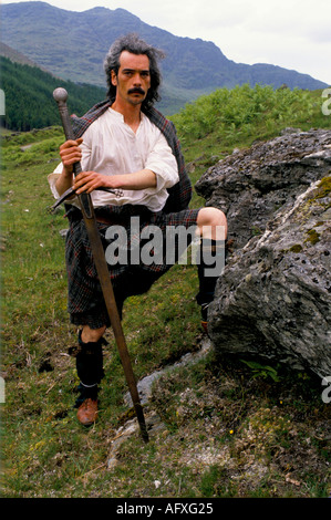 Kilts il Clan un gruppo di reenactment scozzese vestito per la battaglia di Culloden un tradizionale kilt lungo. Glen Croe Scozia 1990 Regno Unito HOMER SYKES Foto Stock