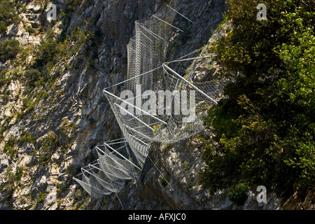 Lavoro a rete di filo usato per arrestare la caduta di rocce su strade di montagna nelle Alpes Maritimes Francia Europa Foto Stock