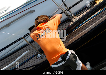 Membro di equipaggio durante la cowes week in appoggio sul lato della barca dopo lunghe giornate racing nel solent isola di Wight Foto Stock