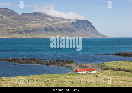 Piccolo rosso con tetti degli edifici agricoli Fasrudsfjordur Stodvarfjordur vicino Oriente Islanda fiordi EU Europe Foto Stock