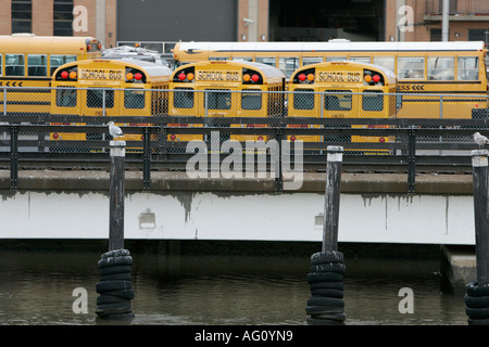 Giallo scuola-bus in un parcheggio accanto all'East River new york city new york STATI UNITI D'AMERICA Foto Stock