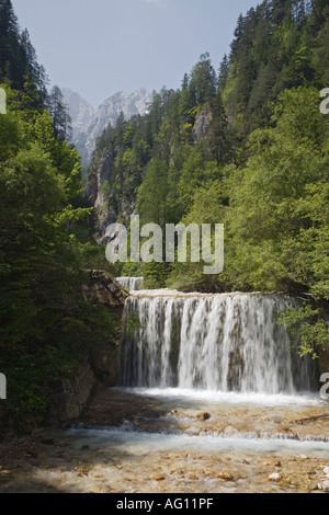 Cascata su weir lungo il fiume Martuljek con Julian Alps al di là in 'Il Parco Nazionale del Triglav'. Gozd Martuljek Slovenia Foto Stock