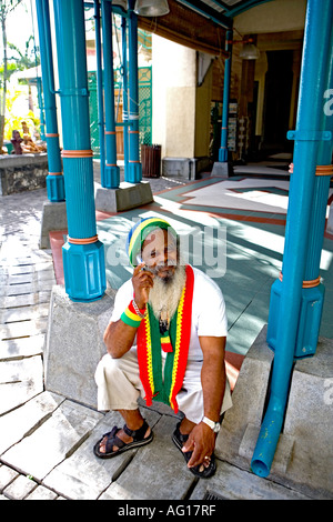 Il carattere locale artista sul telefono cellulare - Caudan, Mauritius Foto Stock