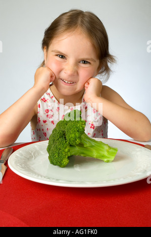 Ragazza giovane non è contento di dover mangiare broccoli Foto Stock